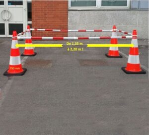 Cône de balisage orange et blanc formant un périmètre de sécurité sur chaussée, kit de signalisation haute visibilité.