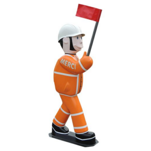 Figurine pédagogique Arthur ou Zoé en tenue orange, casque blanc et drapeau rouge, signifiant « MERCI », utile près des écoles pour rappeler le respect des limitations.