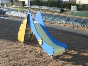 Toboggan de aire de jeux en résine jaune et bleu, avec glissière bleue et structure jaune, fabrication française.